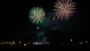 Colorful manchester fireworks bursting in the night sky over a festive crowd.